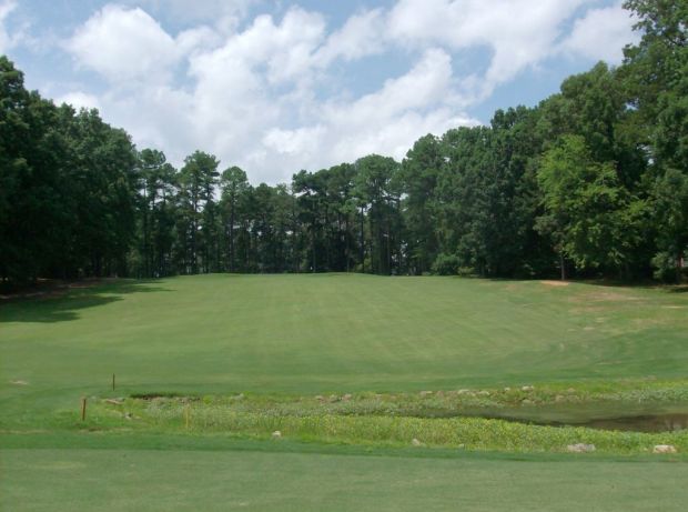Golf course with trees along both sides of the fairway
